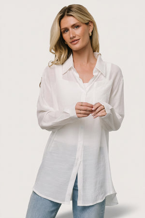 Front view of Breck Button Up Top in off white; lightweight linen-like fabric, left chest pocket, and button cuffs.