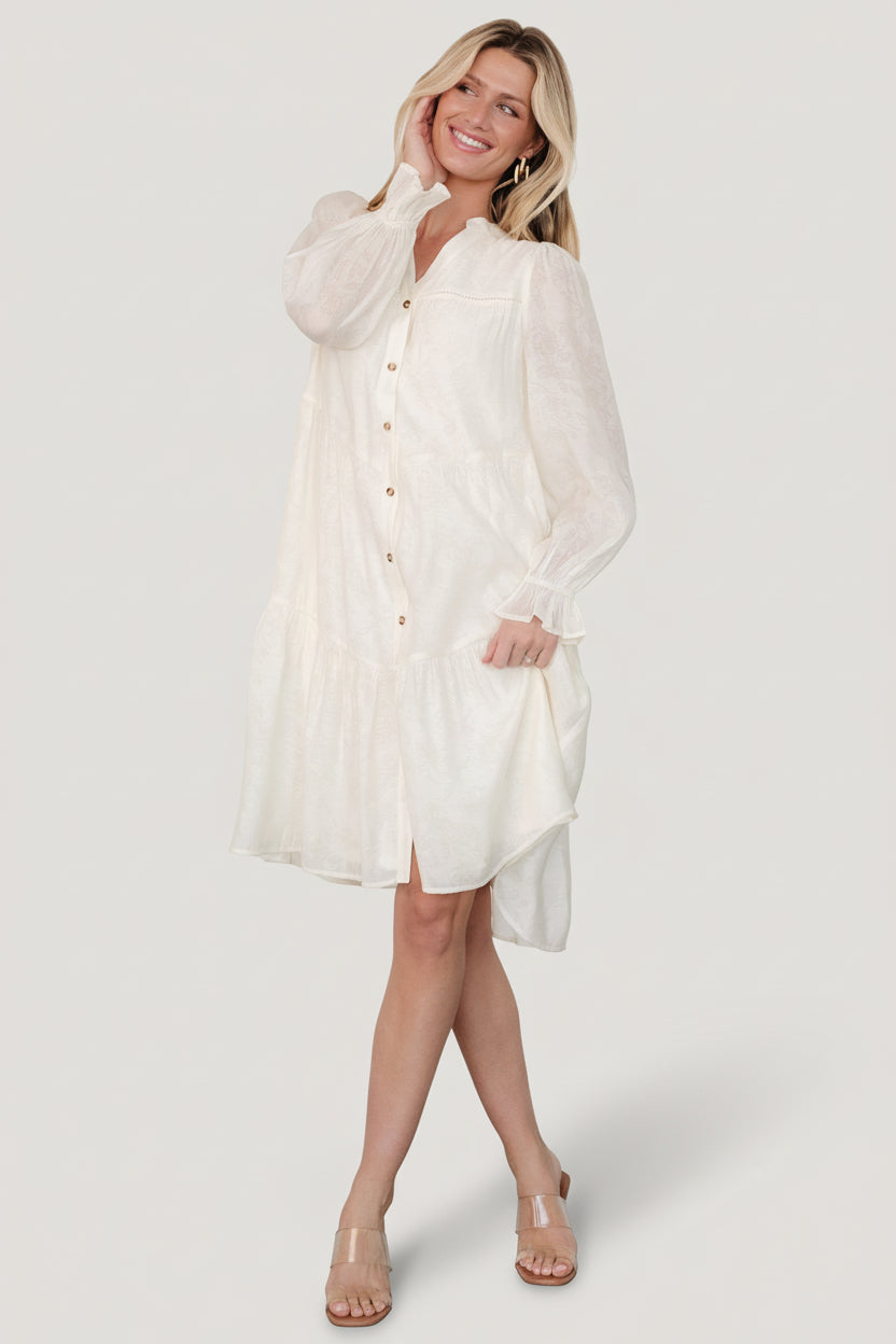 Front view of cream Brenna button midi dress showing V-neck, functional button front, opaque floral pattern and side pockets.