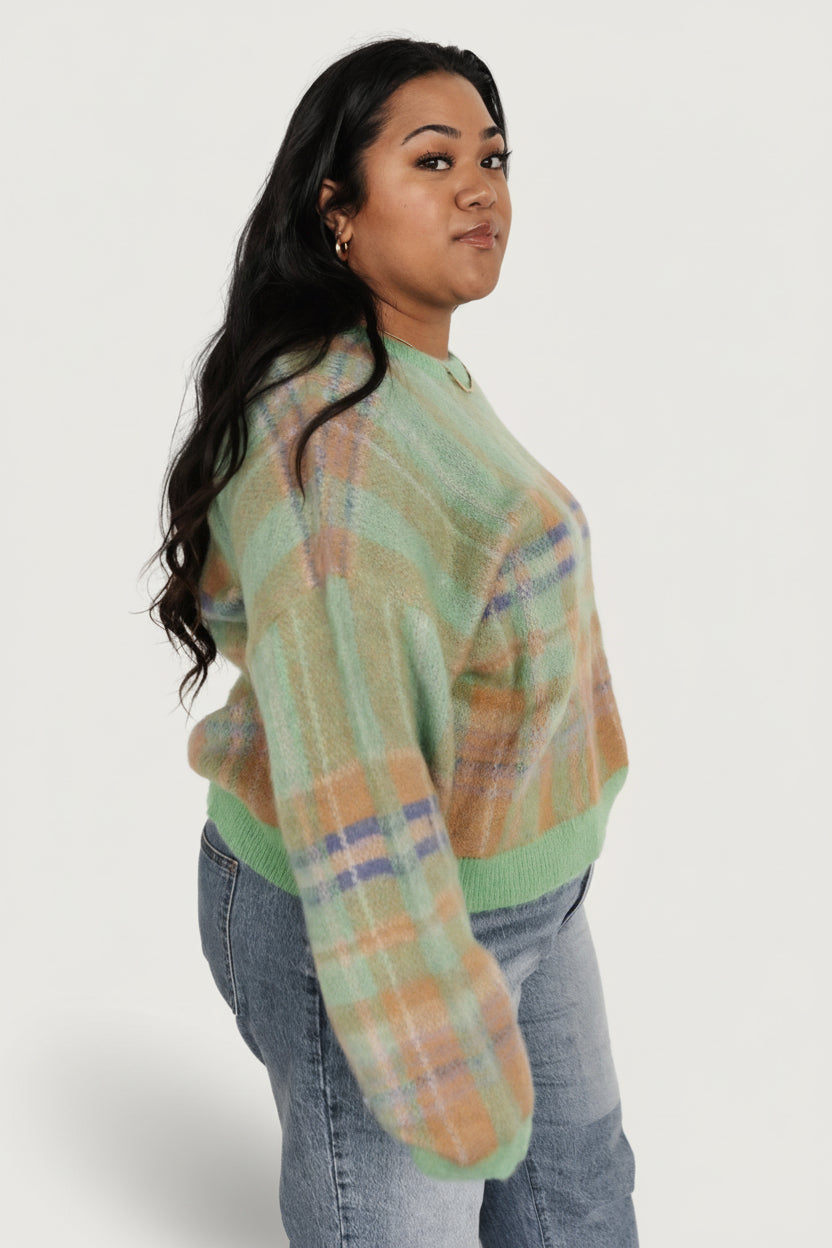 Lifestyle image of the green multi plaid sweater on a model, emphasizing color contrast, drape, and relaxed styling details.