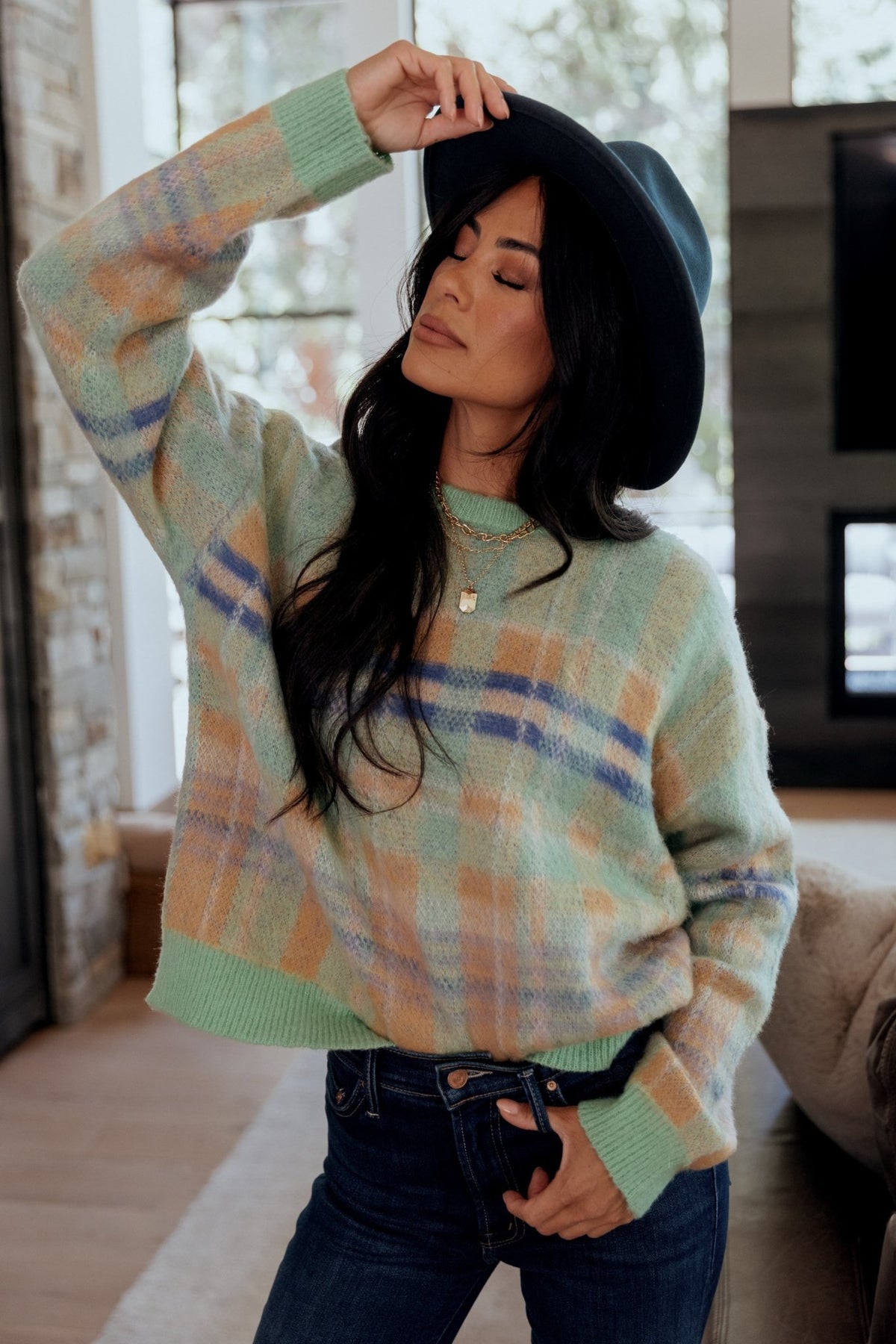 High-resolution close-up of plaid pattern and yarn blend showing color blocking and the sweater's soft, slightly fuzzy texture.