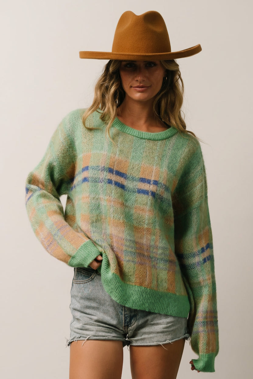 Side view of the green multi plaid sweater illustrating the drop-shoulder seam, relaxed silhouette, and mid-hip length.