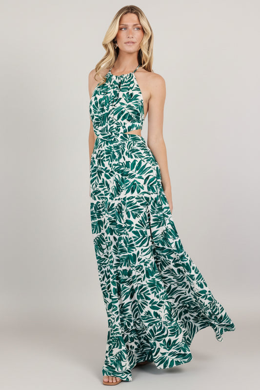 Front view of halter maxi dress in cream with deep green palm print, halter neckline and flowing ankle-length skirt.