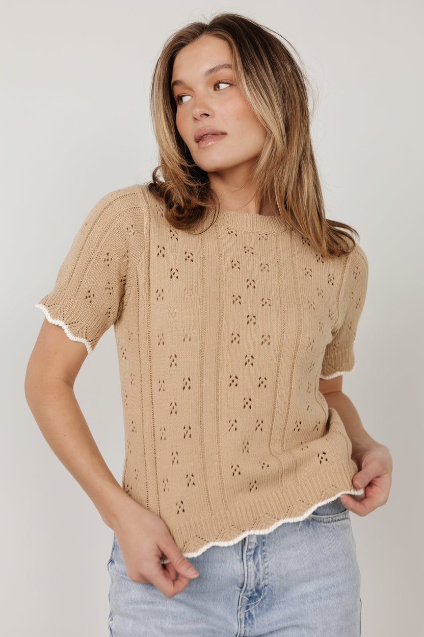 Side view of Britt Pointelle Knit Top in Natural + Ivory on model, showing fit through the torso, scalloped hem, and soft textured pointelle pattern.