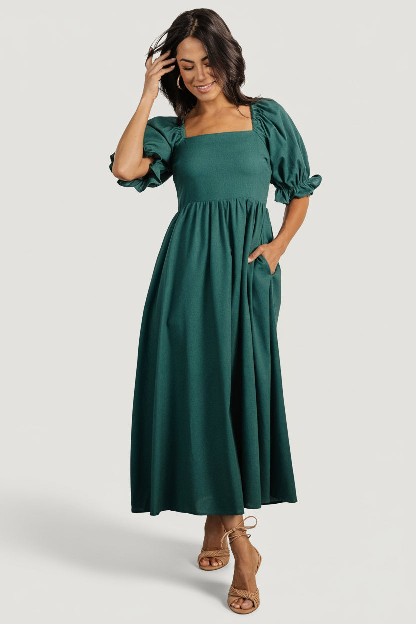 Fabric and bodice close-up of Evergreen smocked midi dress, showing viscose-linen weave, smocking detail and elastic at the shoulder seam.