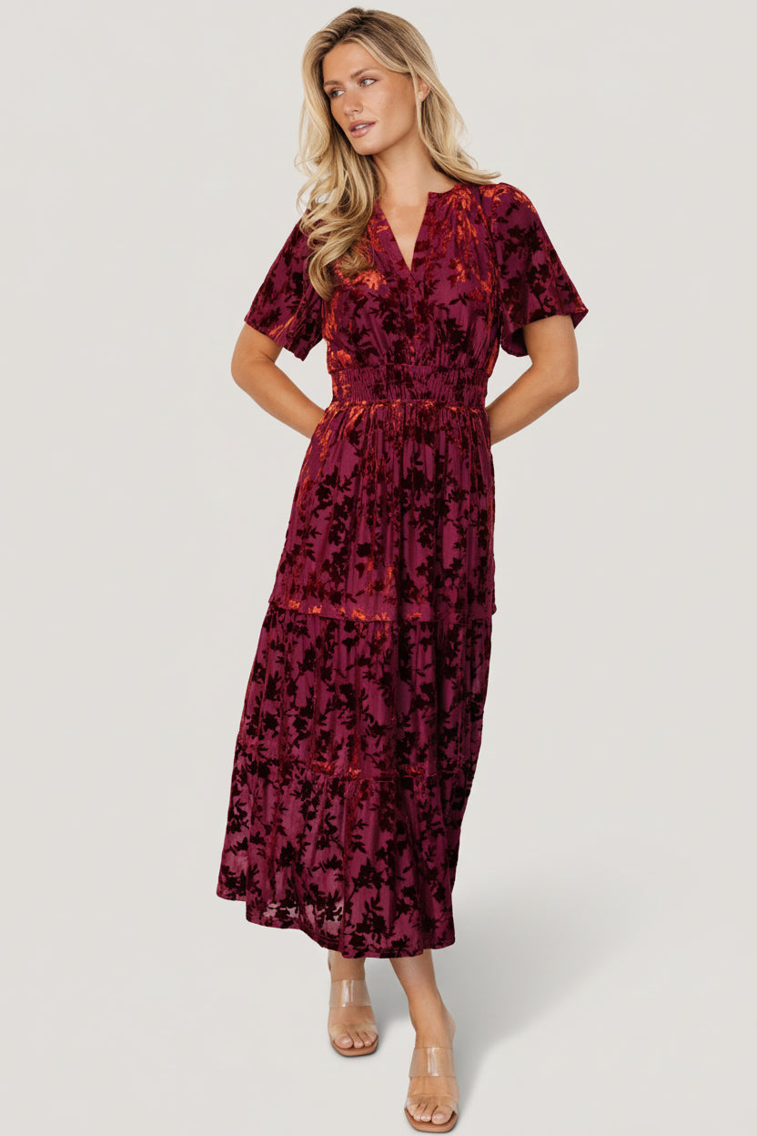 Full-length view of the Bronwyn burnout velvet midi dress in rust floral print on model, showing overall silhouette and flutter sleeves.