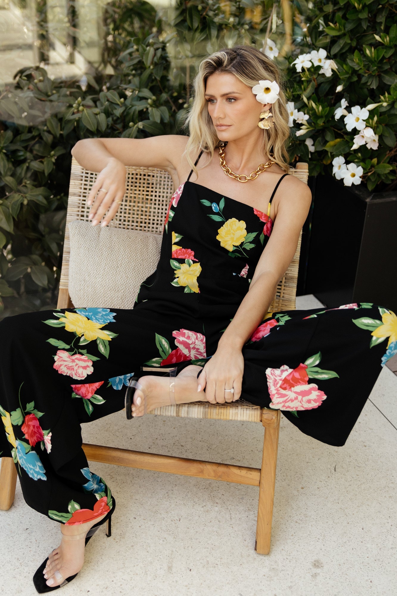 Styled look: black floral jumpsuit paired with neutral heels, emphasizing its versatile high waist, wide legs and elegant printed chiffon.