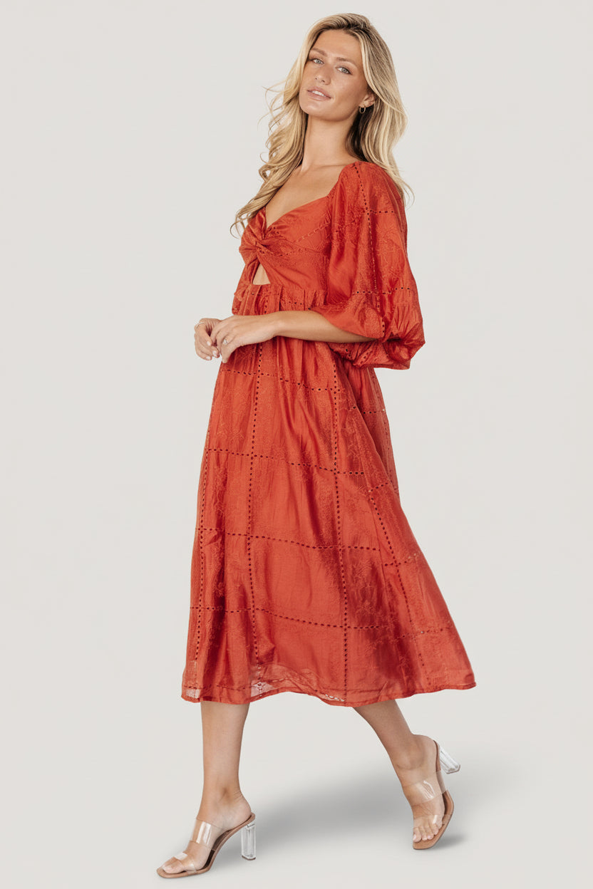 Back view of Brynn rust midi dress displaying self-tie back detail, elasticated back waist, and midi-length hemline.