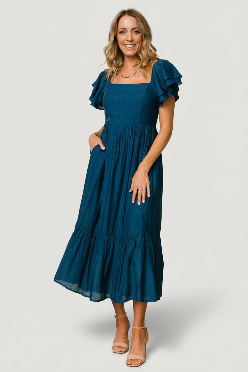 Model front view wearing deep blue Buttercup Midi Dress with square neckline and tiered ruffle sleeves, showing overall fit and shape.