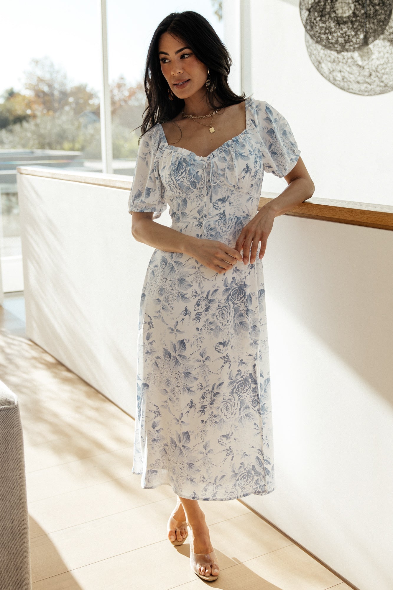 Full-length shot of Cadence Midi Dress in blue floral highlighting the midi length, A-line silhouette, and left-side slit for movement.