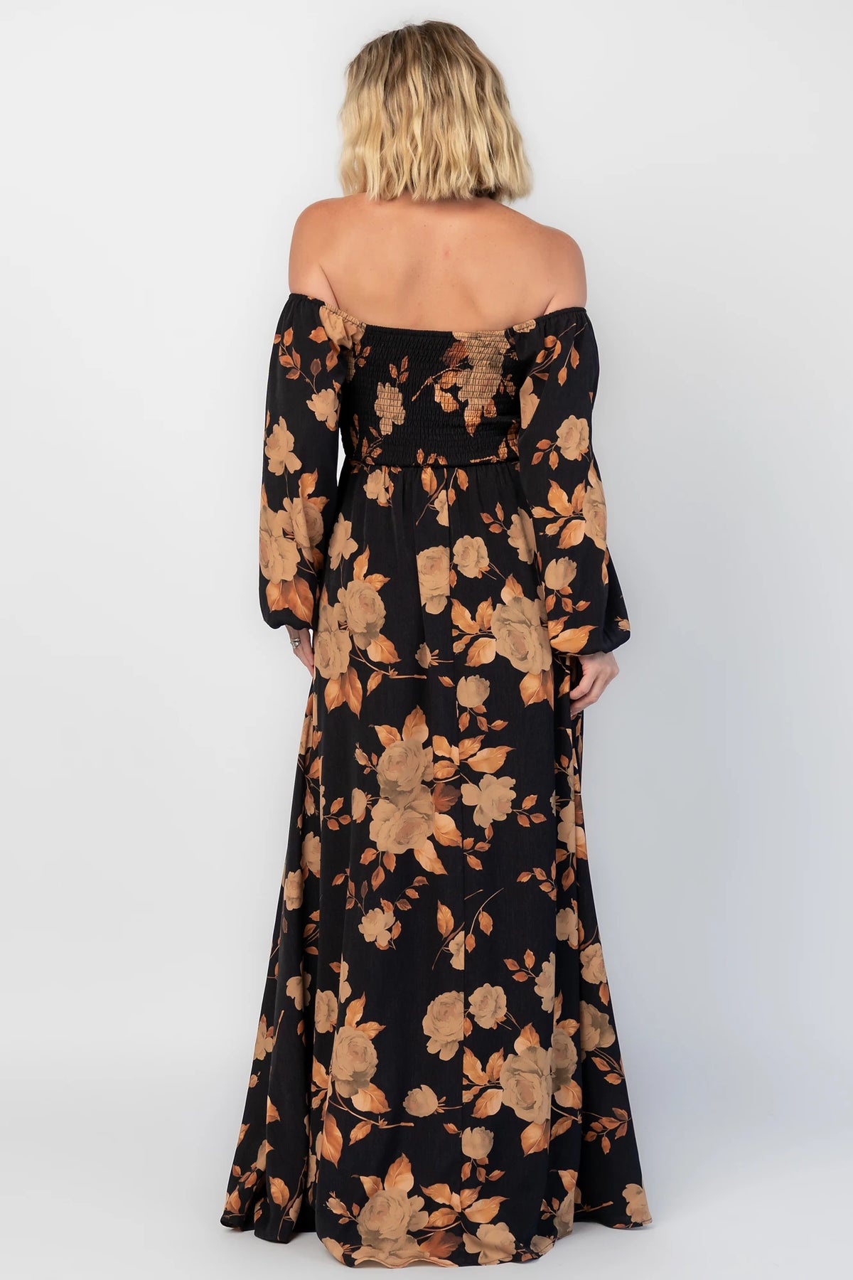 Cordelia Off Shoulder Maxi Dress in Black + Gold Floral with an off-shoulder neckline, billowy sleeves, and a leg slit.