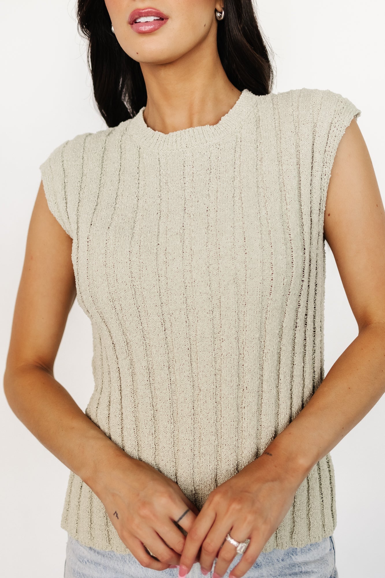 Close-up detail of the ribbed knit texture and stitch pattern on the Dava top in dusty sage, illustrating the soft, spongy hand of the fabric.