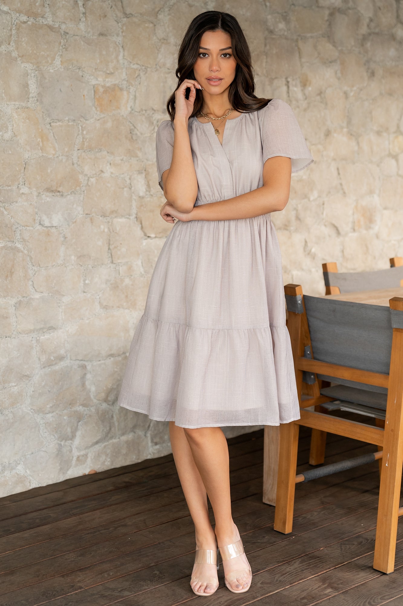 Detail shot of Dita short dress showing V-neckline, gathered shoulder seam, and tiered short skirt edge for a light, airy finish.