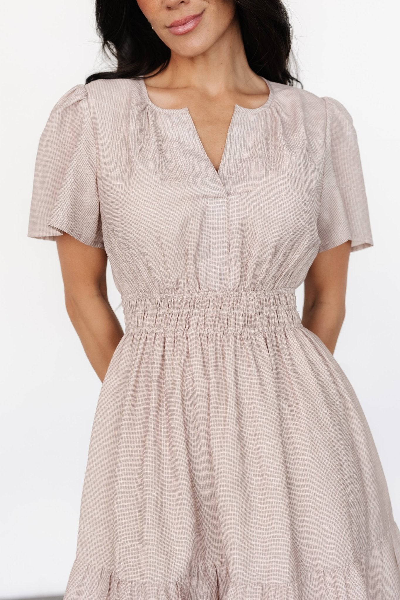 Back view of Dita short dress in natural check, displaying the fully lined bodice and skirt, and the sheer flutter sleeves left unlined.