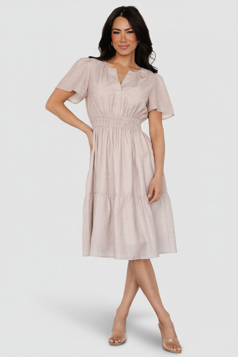 Front view of Dita short dress in natural small-check pattern, showing notched V-neck, smocked elastic waistband, and sheer flutter sleeves for a feminine silhouette.