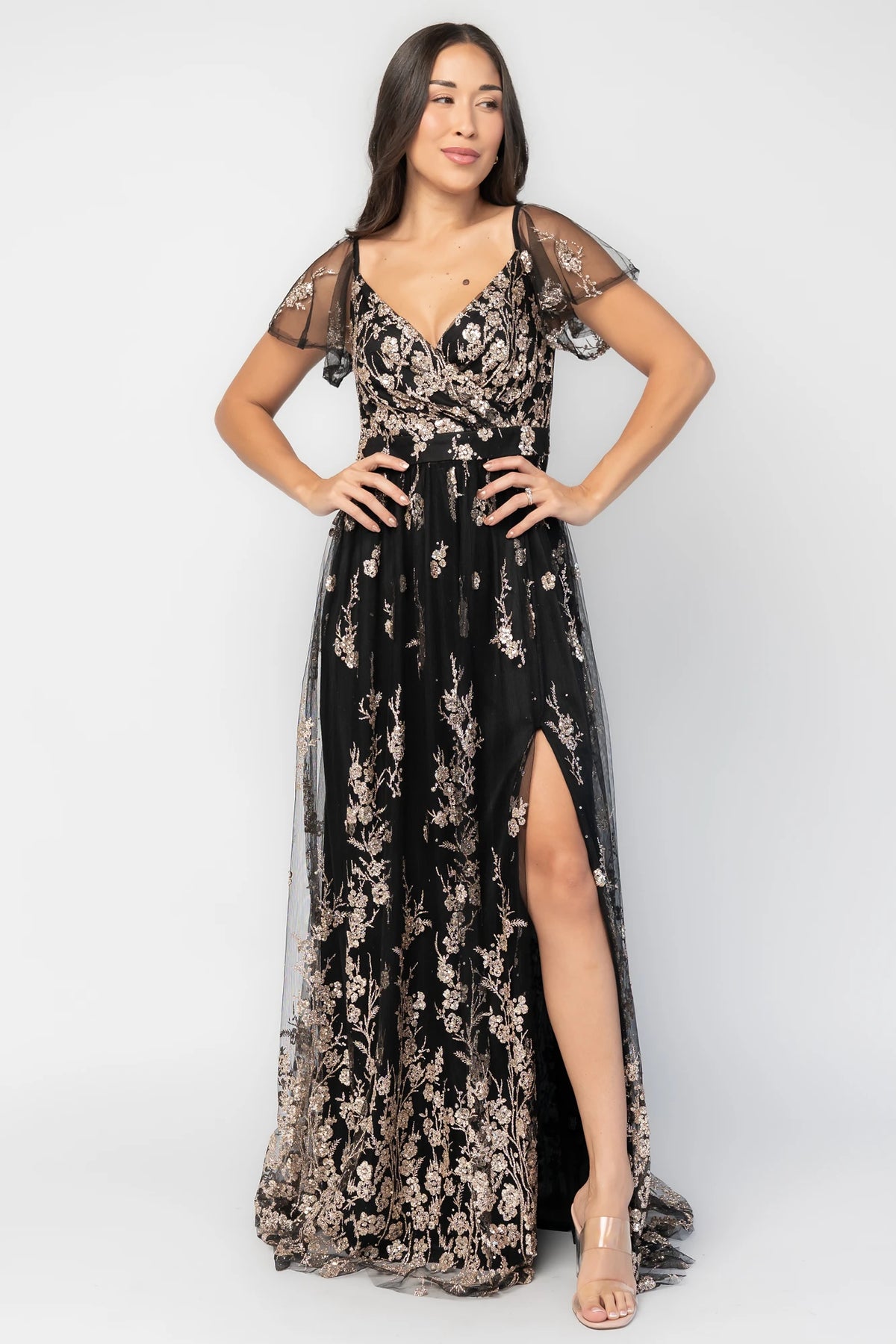 Esmerelda Shimmer Gown in Black + Rose with floral sequin embroidery, surplice V-neckline, flutter sleeves, and front slit.