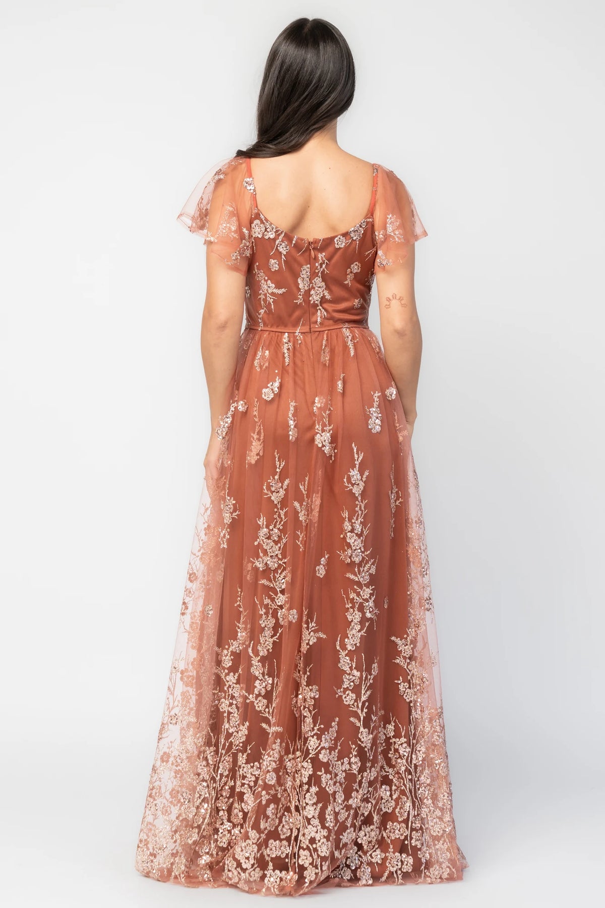Esmerelda Shimmer Gown in Terracotta with floral sequin embroidery, surplice V-neckline, flutter sleeves, and front slit.