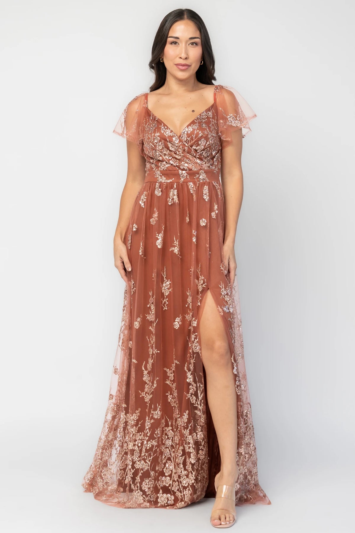 Esmerelda Shimmer Gown in Terracotta with floral sequin embroidery, surplice V-neckline, flutter sleeves, and front slit.