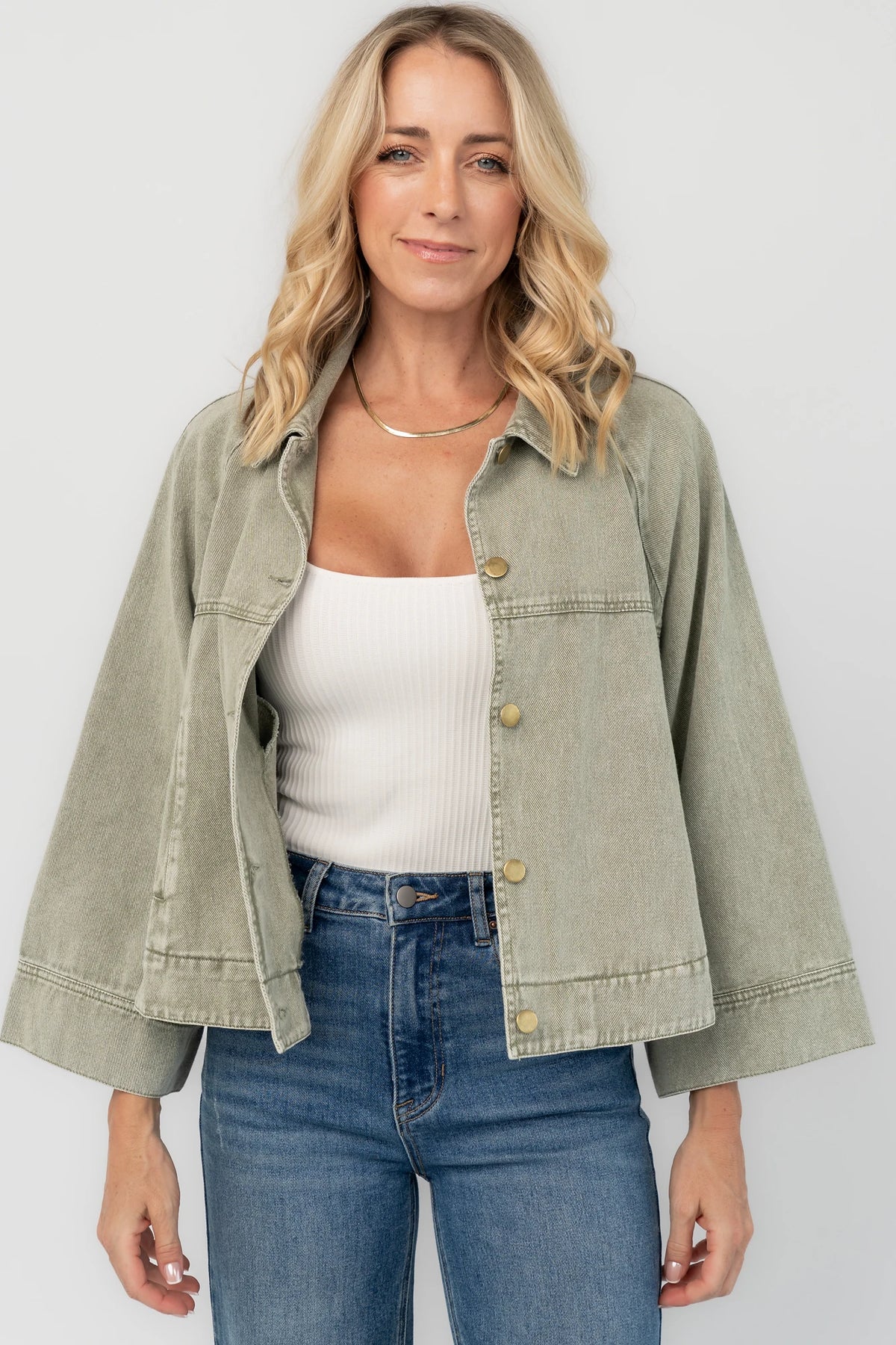 Dusty Olive Cropped Cotton Jacket with collared neckline, button front, raglan sleeves, adjustable cuffs, and side pockets.