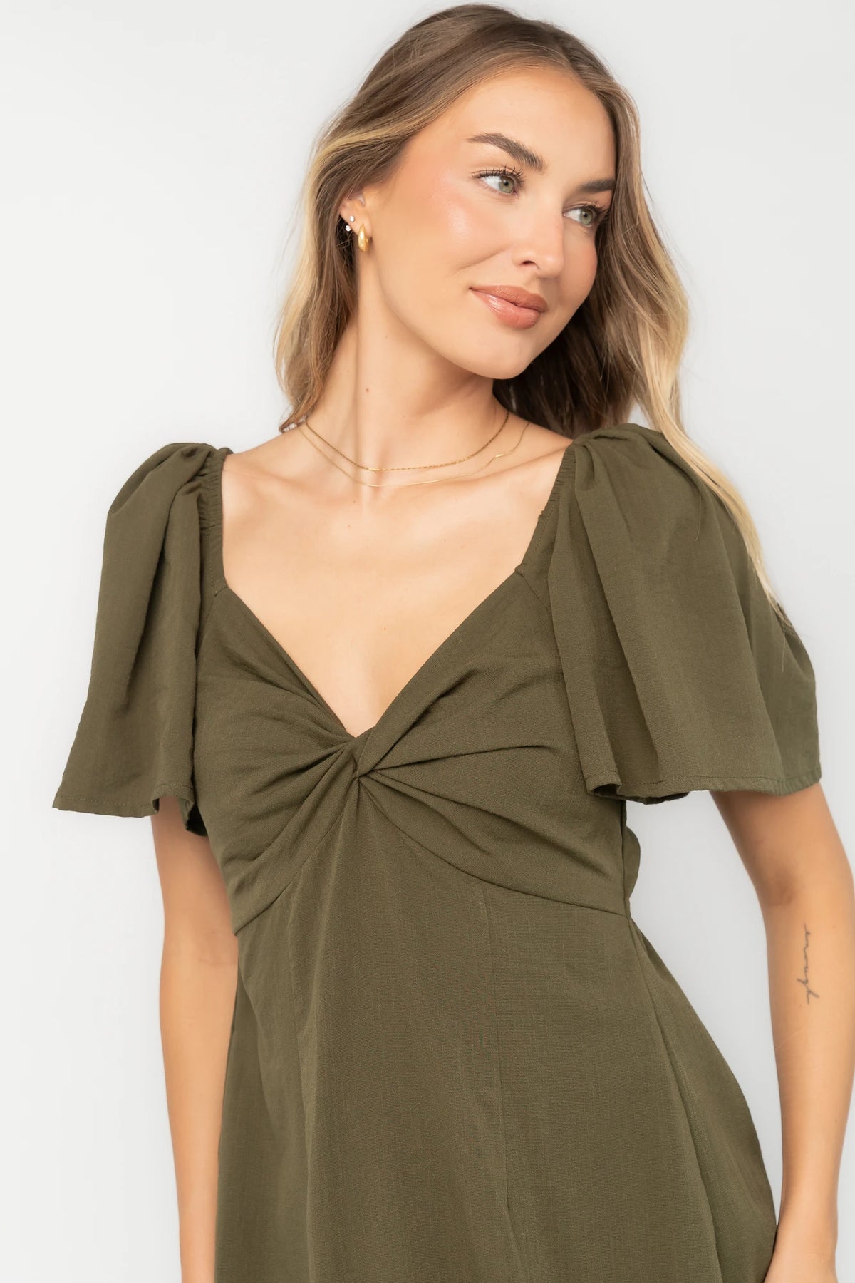 Indie Back Tie Dress in Olive with sweetheart neckline, butterfly sleeves, open tie-back, and side pockets.
