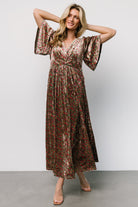 Full-length on-model image showing overall drape, flutter sleeves, empire waist placement and how the partially lined skirt moves with a left slit.