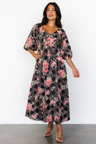 Model wearing Ivanna Embroidered Satin Midi Dress: midi length, high upturned-V waist and flowing skirt in motion.