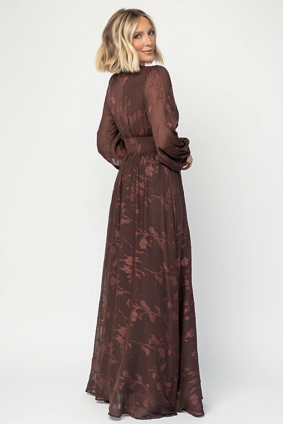 Jennifer Maxi Dress in Dark Mahogany with plunging V-neck, sheer long sleeves, gold sparkle, and textured florals.