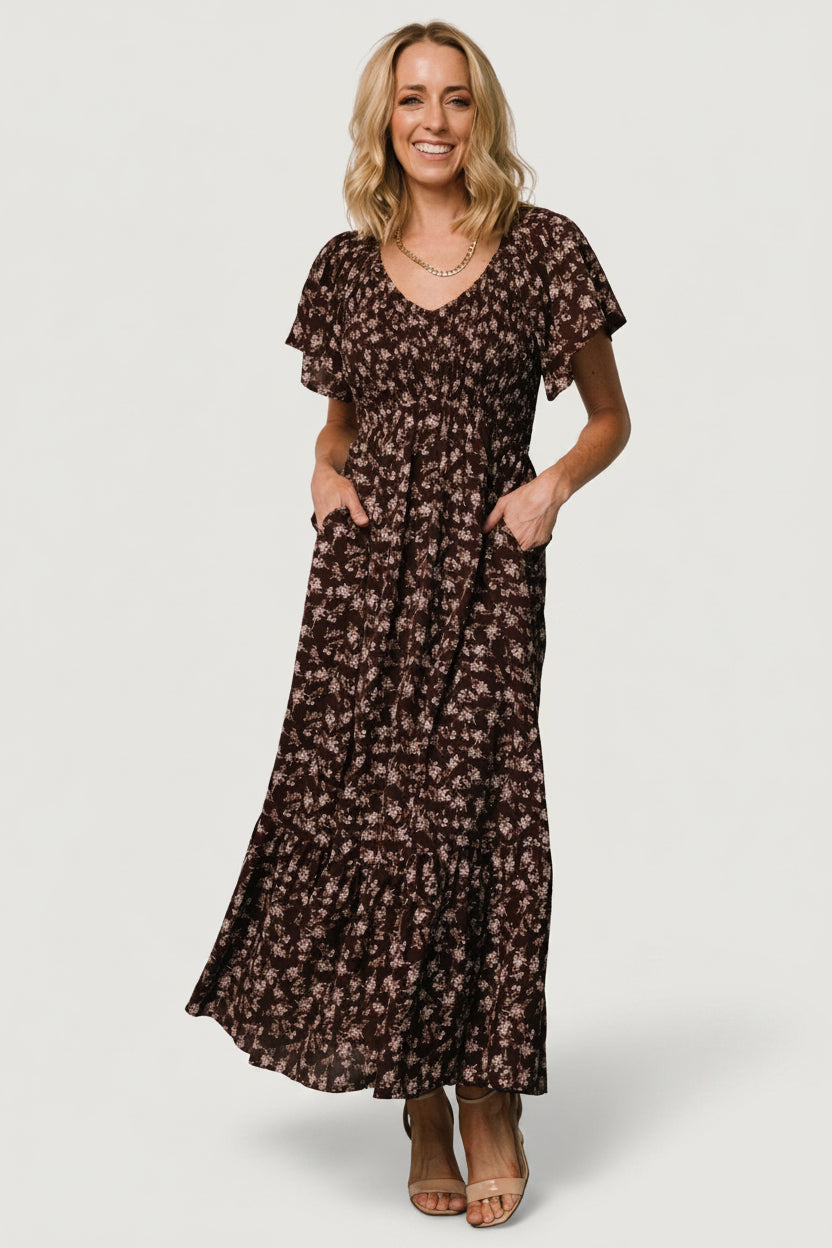 Front view of Joanie Smocked Midi Dress in clove floral, showing smocked bust, V-neckline, flutter sleeves and midi skirt with hidden pockets, on model.