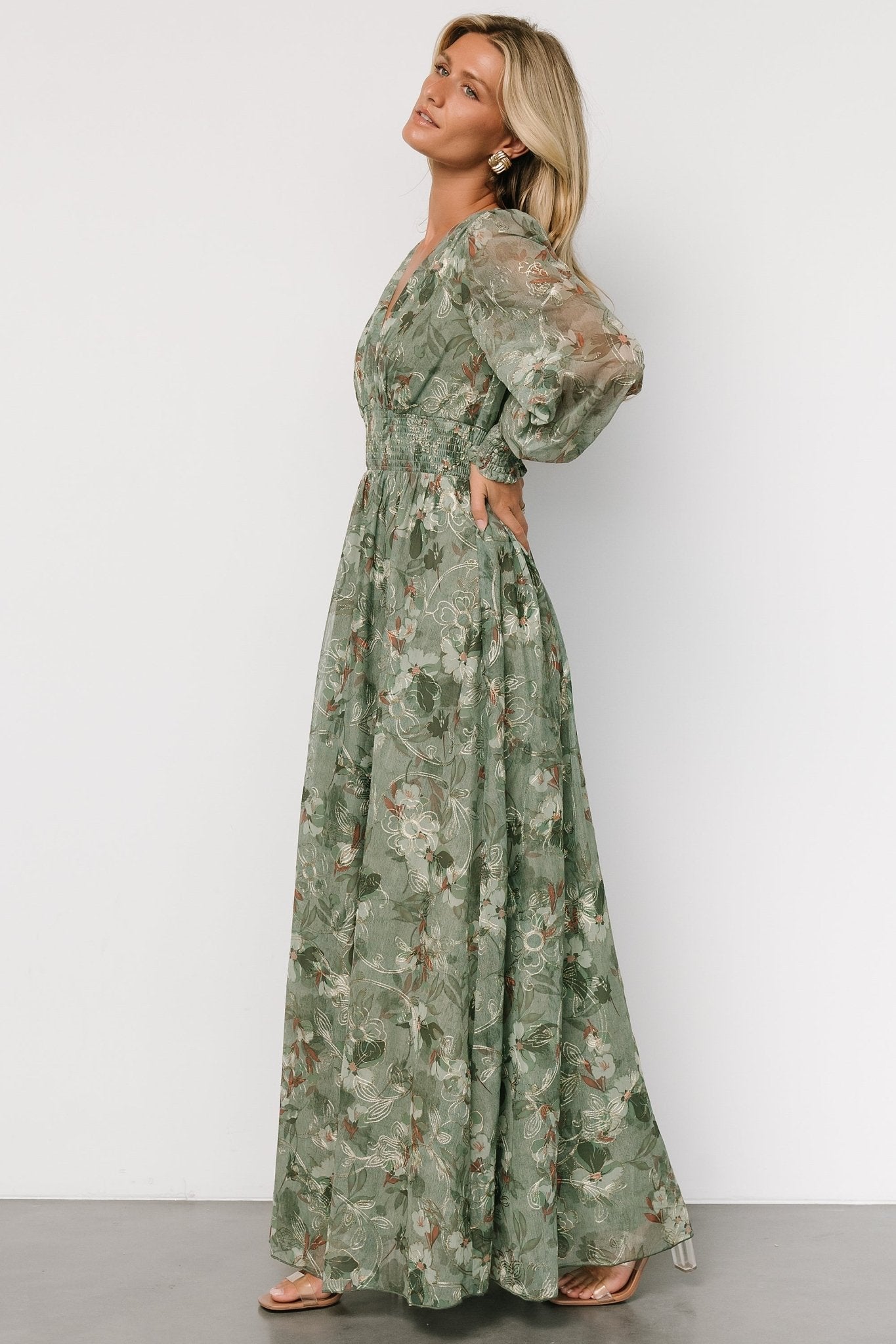 Full-length movement shot of sage maxi dress highlighting airy tulle skirt and subtle gold floral embroidery for occasions.