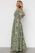 Full-length movement shot of sage maxi dress highlighting airy tulle skirt and subtle gold floral embroidery for occasions.
