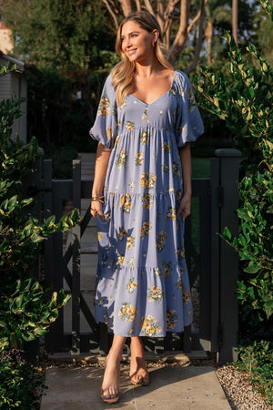 Front view of Judith chiffon midi dress in blue-purple with golden floral print, V-neckline, empire waist and tiered lined skirt for movement.