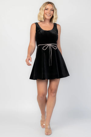 Julieta Short Dress in Black with a velvet finish, scoop neckline, and a rhinestone bow at the front waist.