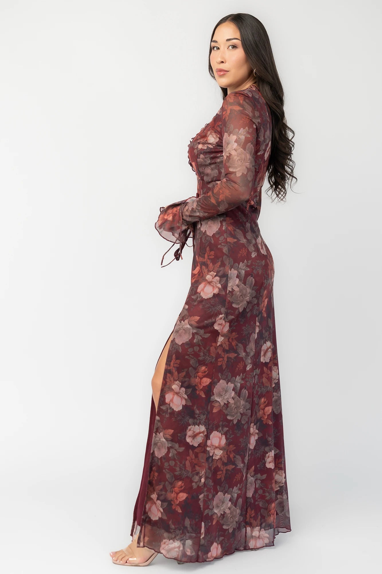 Julietta Maxi Dress in Mahogany Rose Floral with plunging V-neck, sheer long sleeves, ruffle trim, and leg slit.