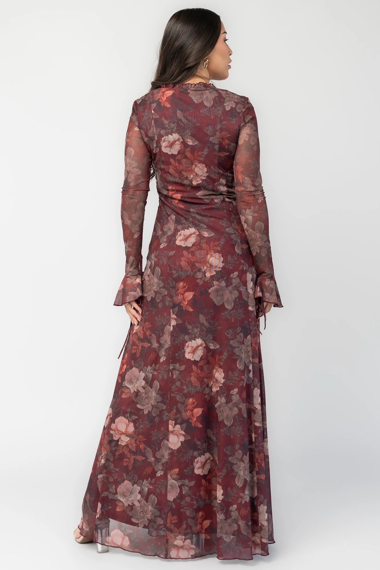 Julietta Maxi Dress in Mahogany Rose Floral with plunging V-neck, sheer long sleeves, ruffle trim, and leg slit.