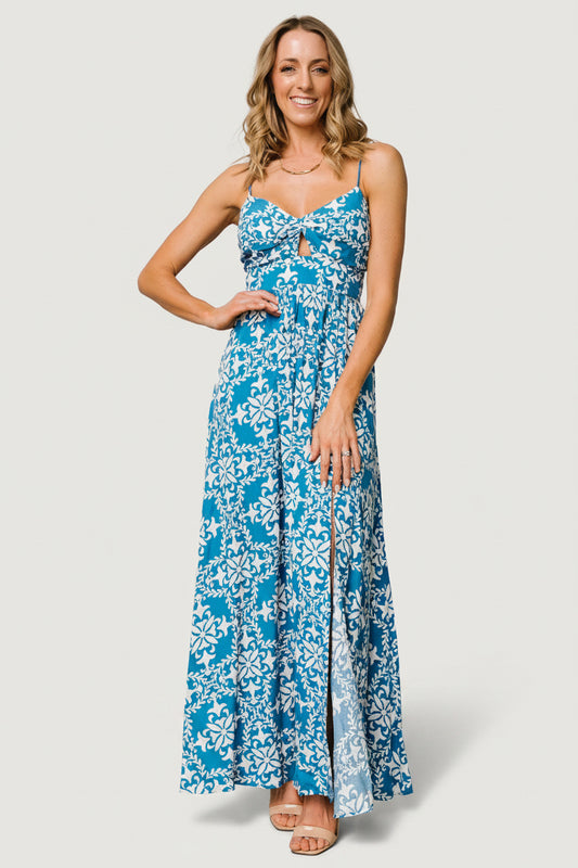 Three-quarter view of the blue floral maxi showing smocked back and empire waist, thin adjustable straps and soft rayon drape.