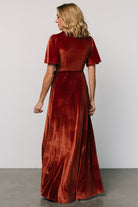 Side view of the Katelyn Cinnamon velvet maxi dress showing tulip skirt silhouette, wrap ties through side loop, and sleeve length for styling reference.