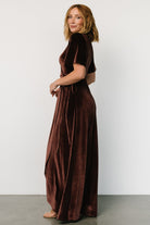 Model wearing the clove velvet wrap dress styled for occasion wear, emphasizing neckline coverage, wrap tie, and flattering silhouette.