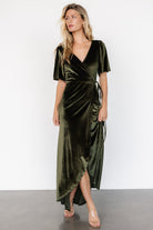 Studio shot of the Katelyn Velvet Maxi Wrap Dress in dark olive on a neutral background, showing front styling and sleeve detail.