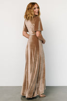 Styled look of Katelyn Velvet Maxi Wrap Dress in warm taupe on model, paired with heels to show length and elegant movement.
