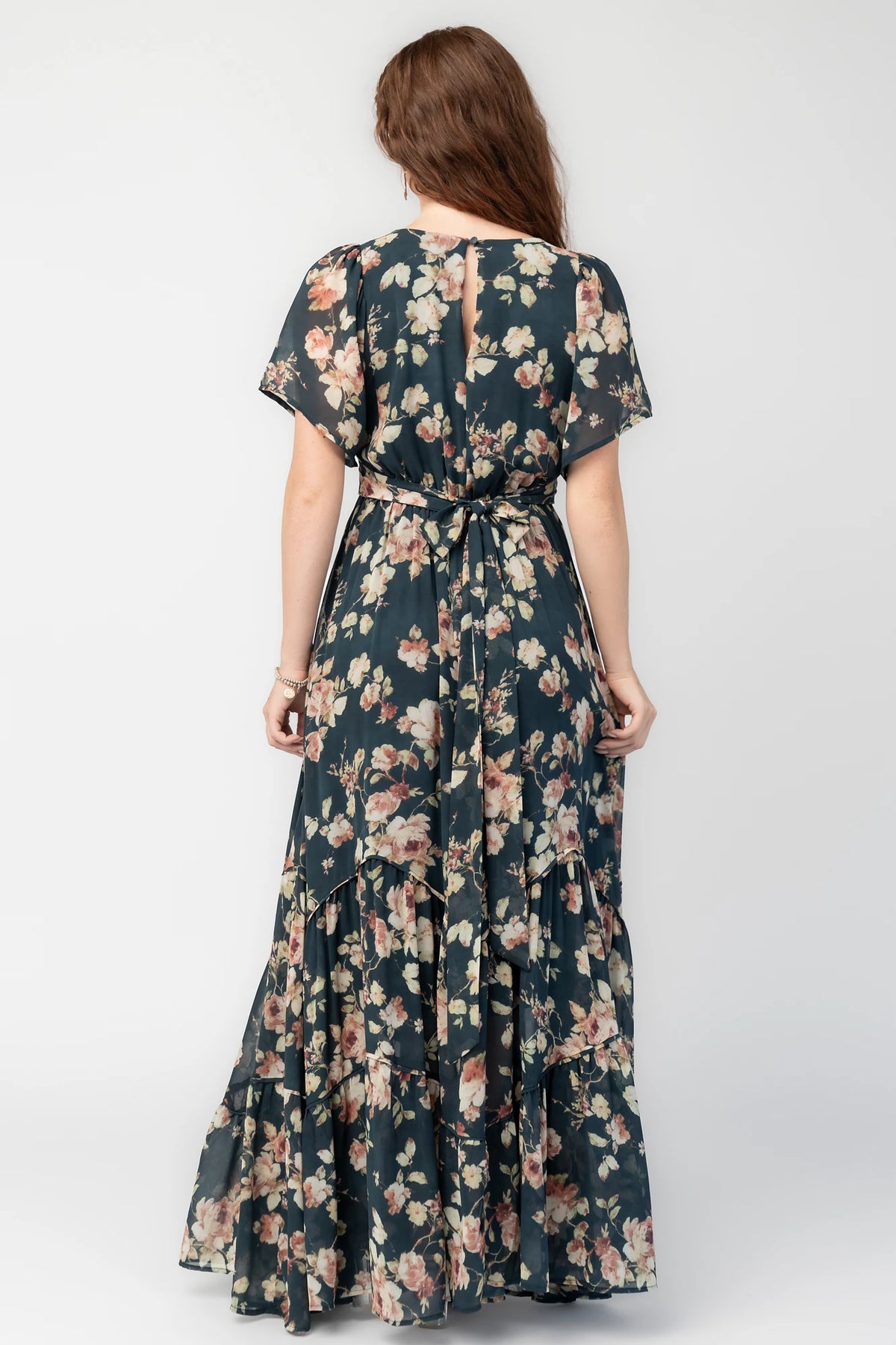 Katherine Maxi Dress in Deep Blue Floral with surplice V-neck, flutter sleeves, adjustable waist ties, and tiered skirt.