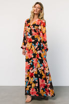 Front view of Katinka Wrap Maxi Dress in Tropical Night Floral; chiffon skirt, surplice neckline, waist tie and flowing hem.
