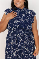 Model walking in blue floral chiffon maxi dress, illustrating airy drape, ruffle hem motion, and the flattering smocked waistline.