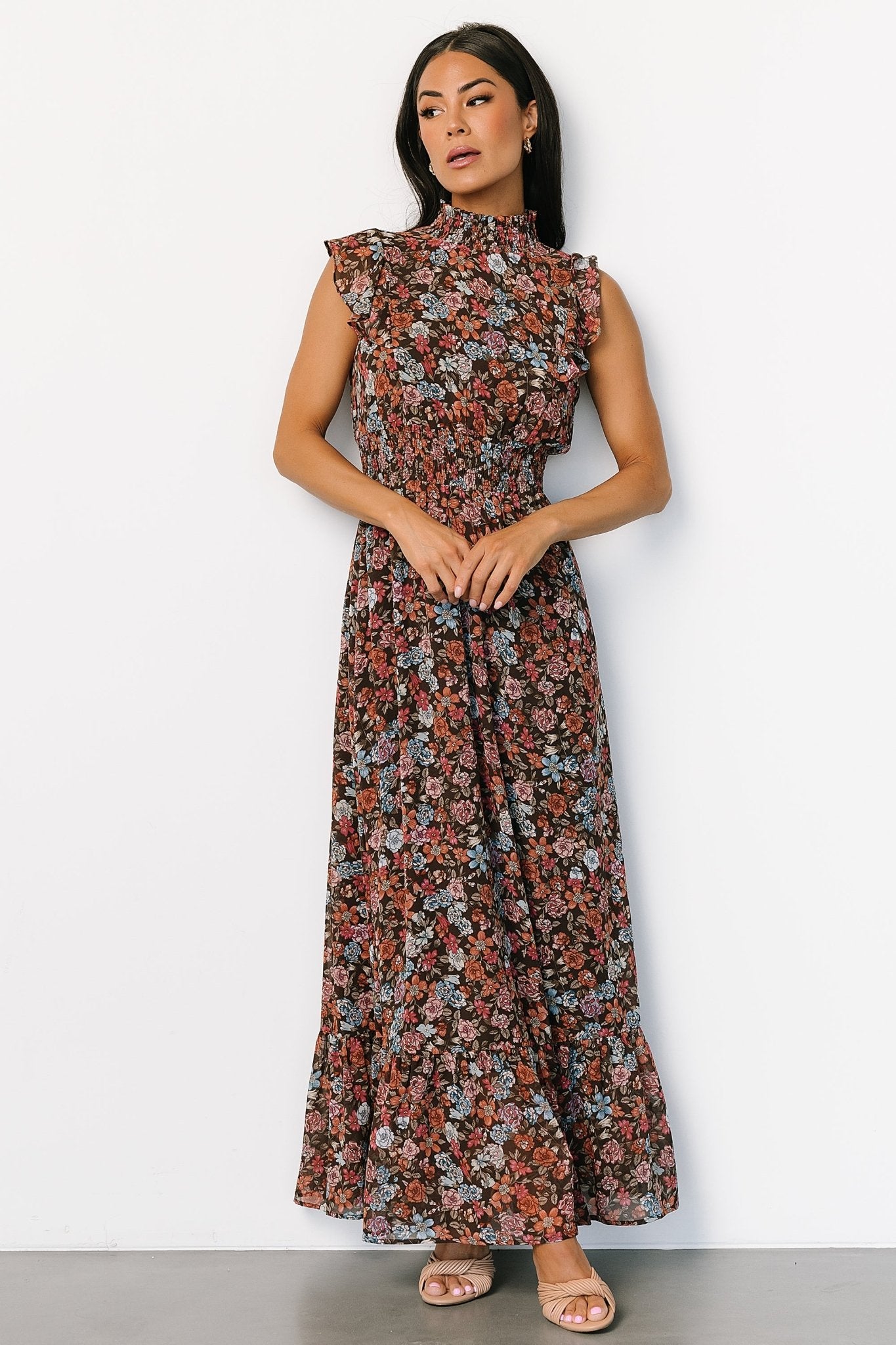 Close fabric and pattern shot of the brown multi floral print, highlighting color palette of pink, orange, and blue on a brown background.