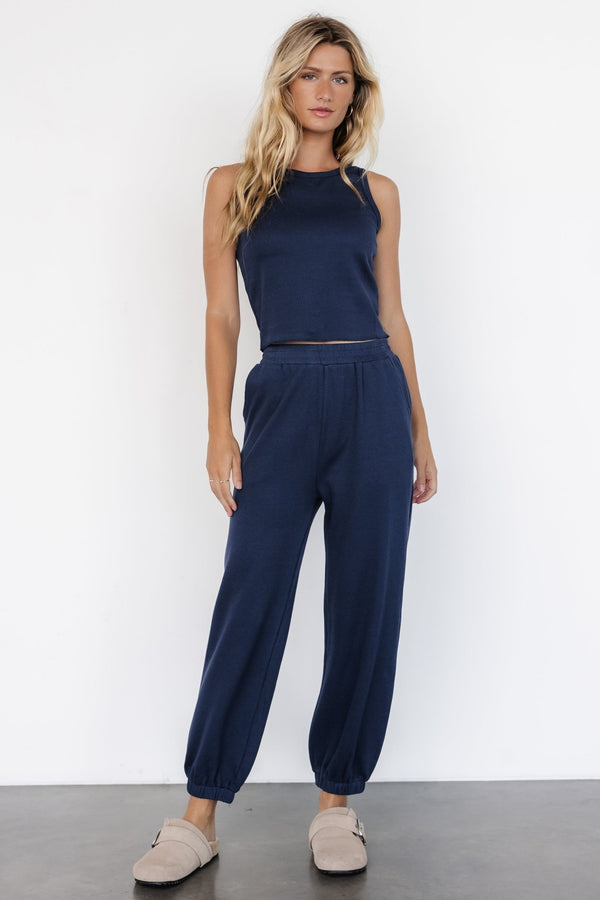 Front view of model wearing navy Kellen tank and matching joggers, showing cropped tank, round neck, elastic waist, and side pockets.