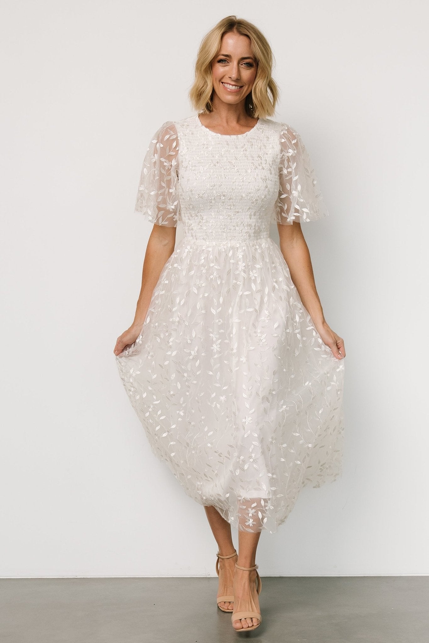 Detail of smocked bodice and lined slip beneath embroidered tulle on Kendra white midi dress, showing interior lining finish.
