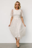 Detail of smocked bodice and lined slip beneath embroidered tulle on Kendra white midi dress, showing interior lining finish.