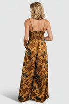 Side view of the Khloe wide-leg jumpsuit emphasizing the banded natural waist panel and hidden side pockets for hands-free convenience.