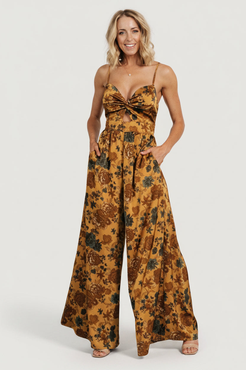 Front view of model wearing Khloe wide-leg jumpsuit in gold multi floral print, showing the sweetheart neckline and flowing palazzo silhouette.