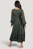 Full-length shot of model in deep olive Lainey dress highlighting the relaxed fit and lined skirt movement.