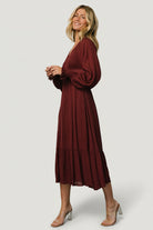Styled look of Lainey mulberry midi dress paired with accessories, highlighting long sleeves, relaxed fit, and versatile day-to-night styling.