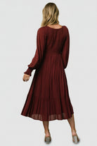Side view of Lainey mulberry midi dress showing V-waist silhouette, tiered hemline, and the dress’s graceful drape while walking.